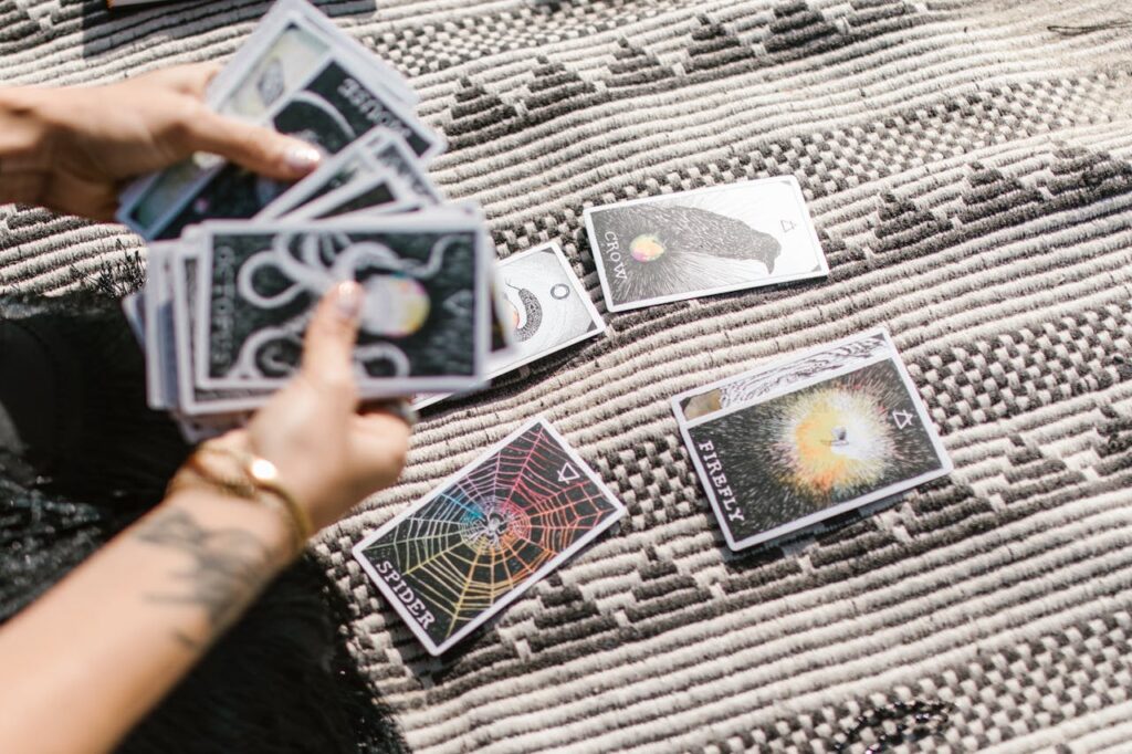 Person Holding Playing Cards on Black and White Textile